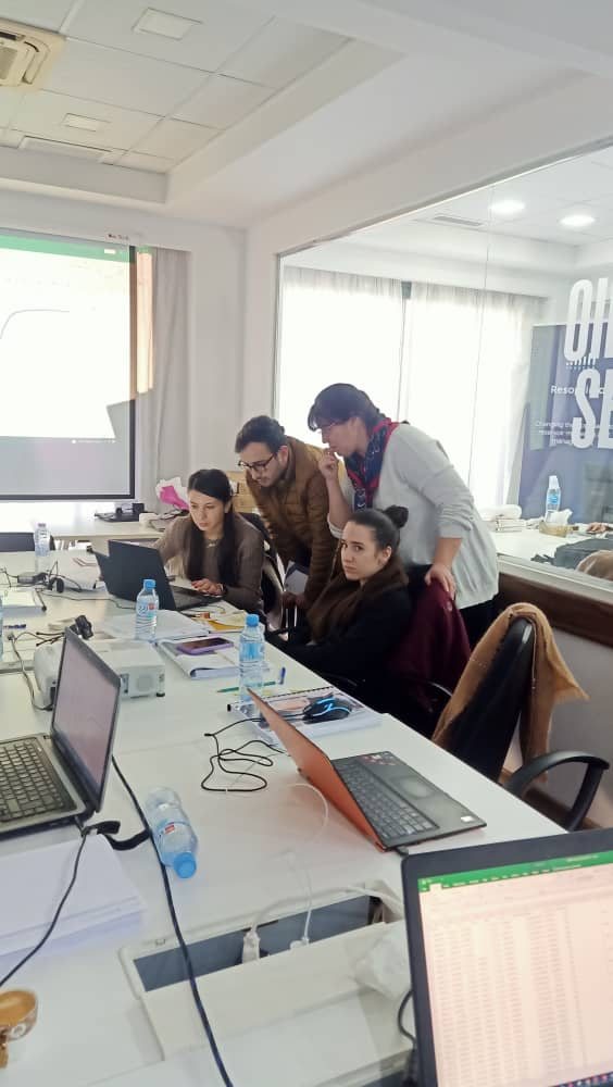 Students at laptops being supported through their assignment during a training session in Algeria.