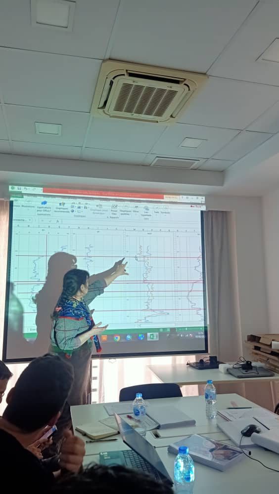 Instructor at a screen walking a training group through a real case study on oil-water contact identification.